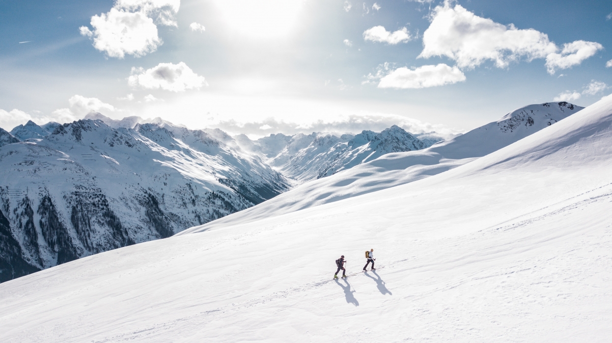 两个人在雪山上徒步旅行4k风景壁纸