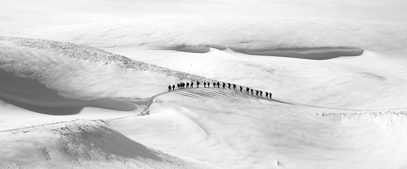 冬季白色山顶上游走的队伍图片