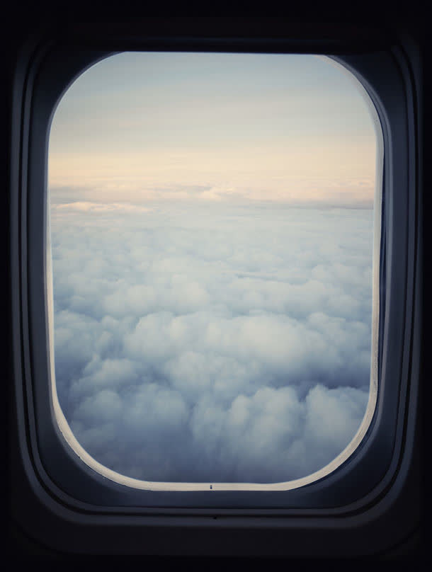 透过飞机的窗户看外面的白云