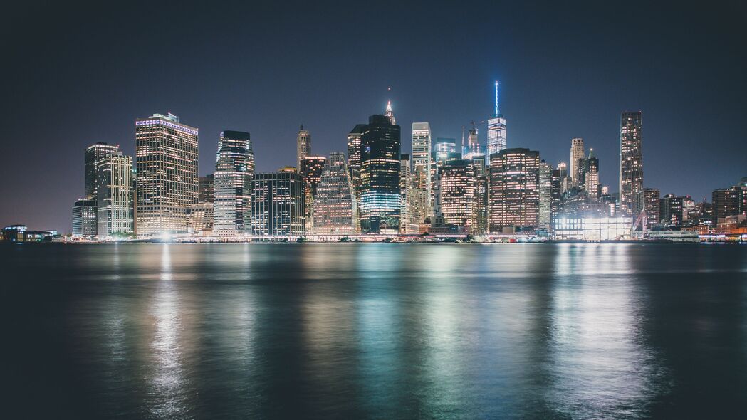 摩天大楼璀璨夜景，灯光辉映大海，城市风光4K壁纸，高清3840x2160下载