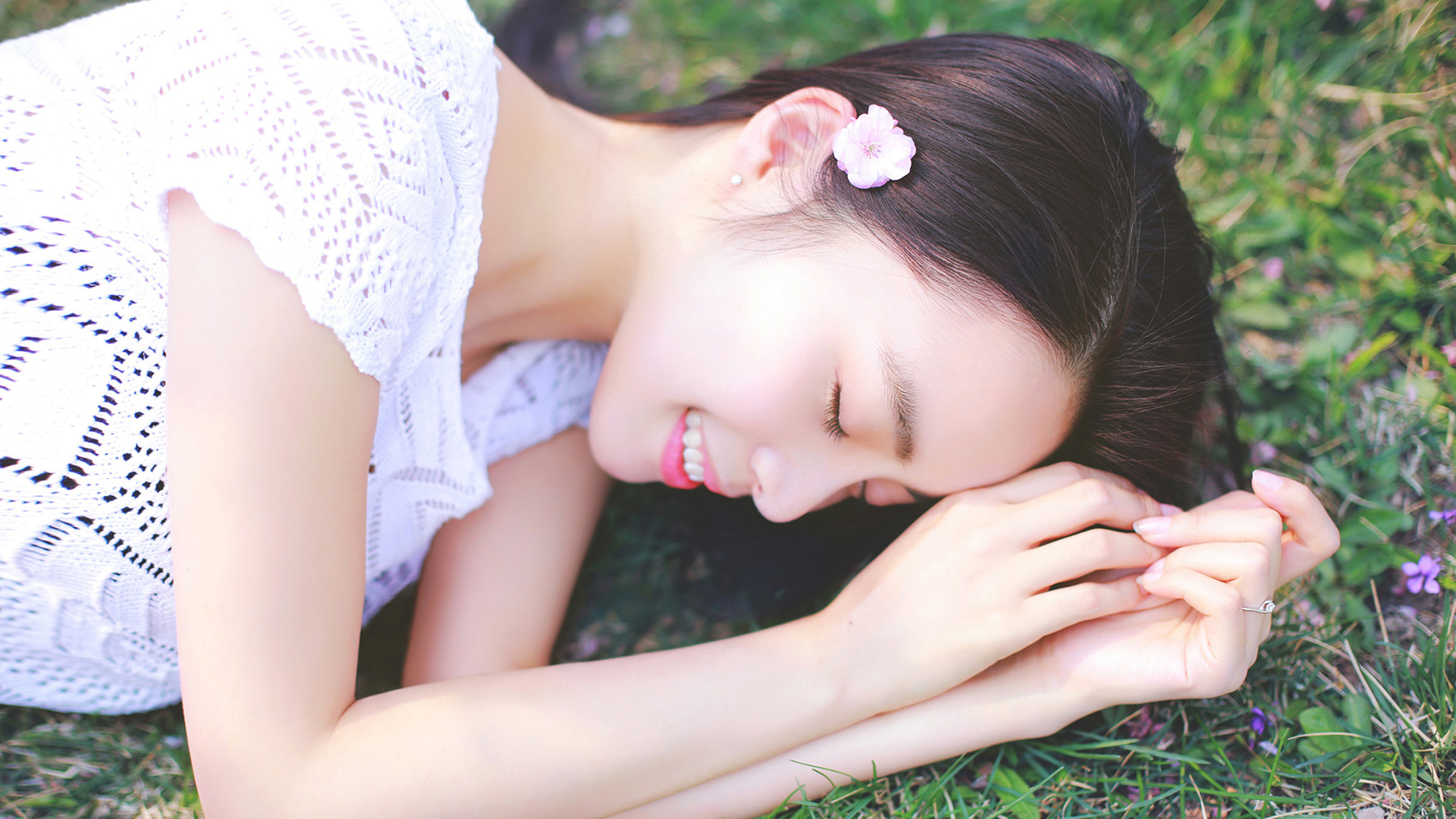 睡在桃花林草地上的清秀少女桌面壁纸