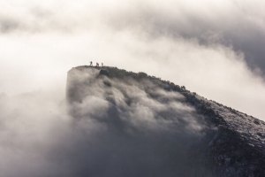 山顶人物攀登云层